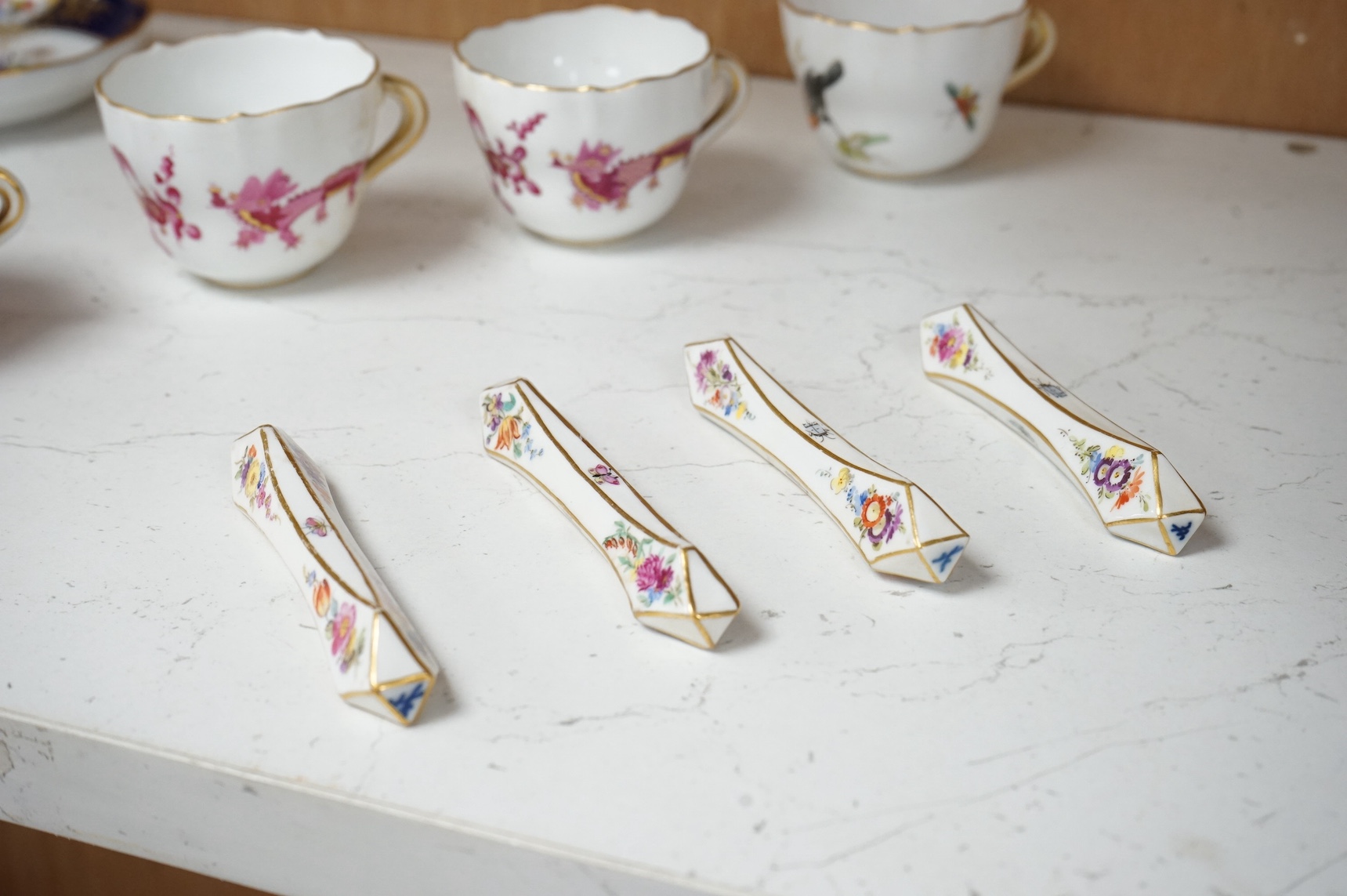 A collection of Meissen cabinet cups and saucers and four knife rests. Condition - varies